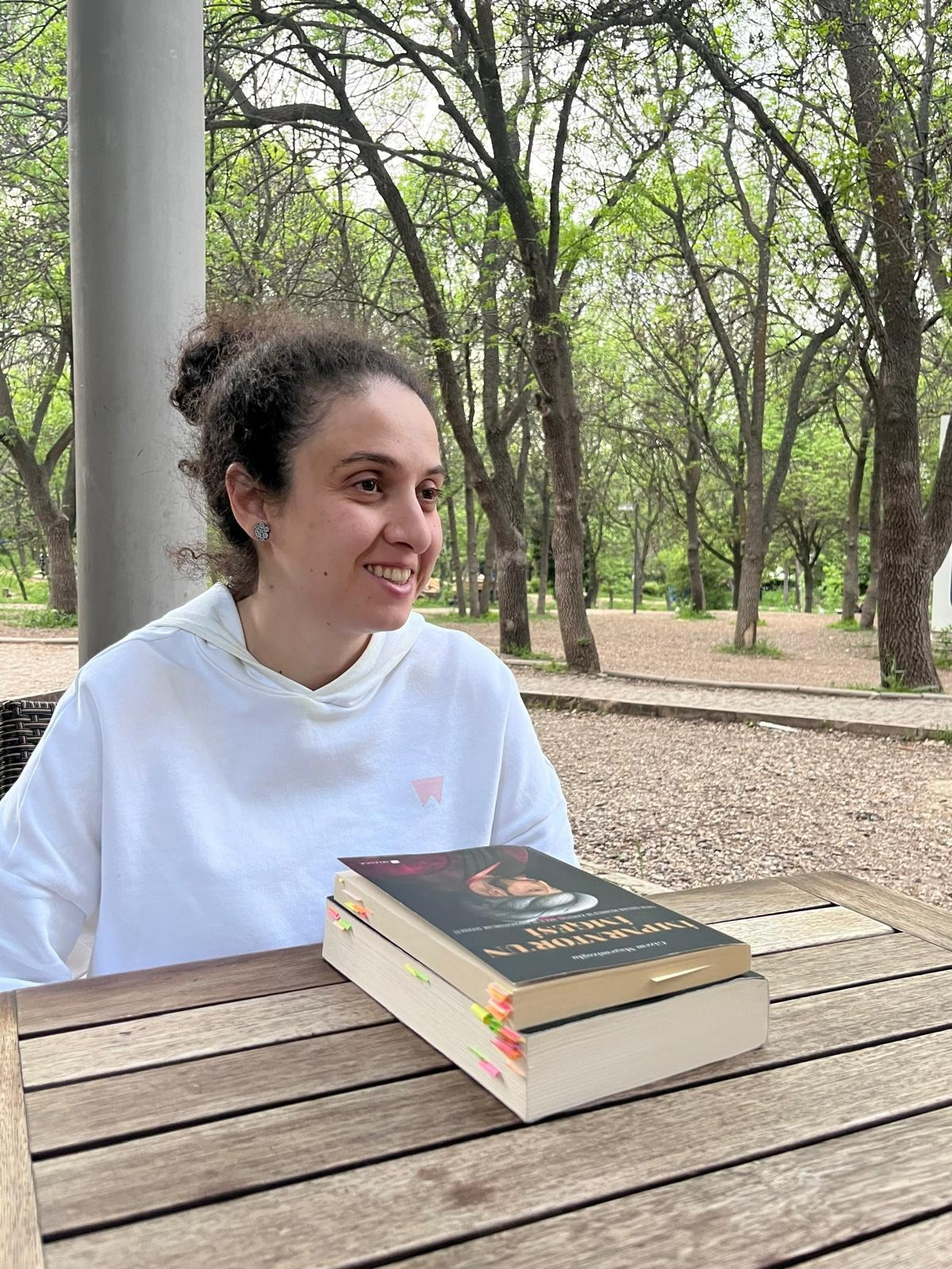 A person sitting at a table with a stack of books

AI-generated content may be incorrect.