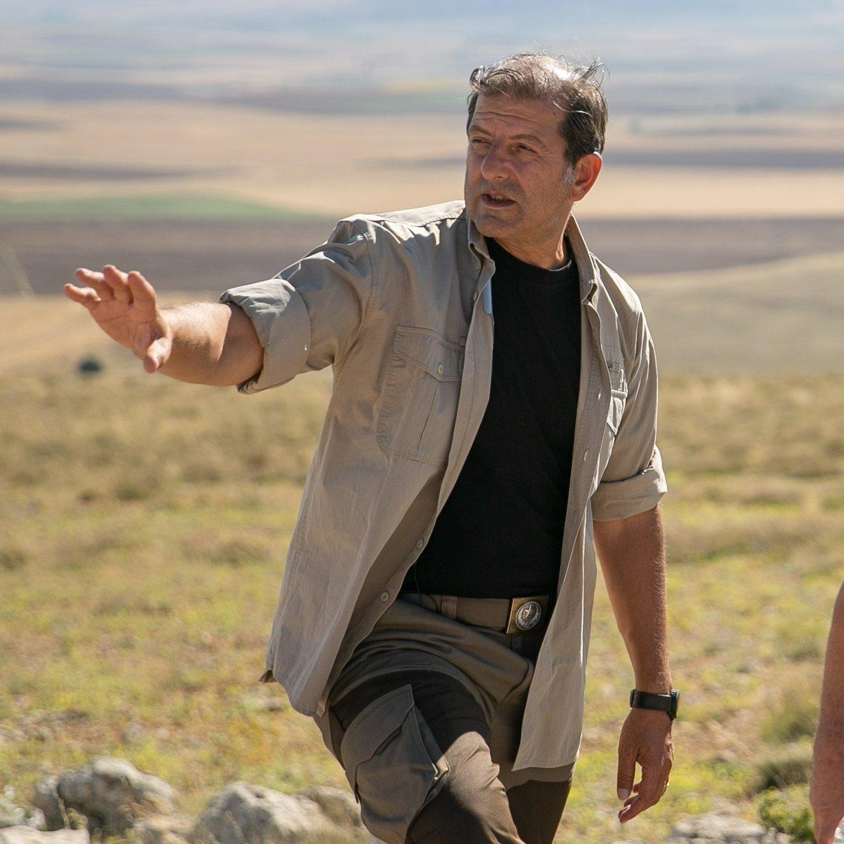 A person walking on a rocky hill

Description automatically generated